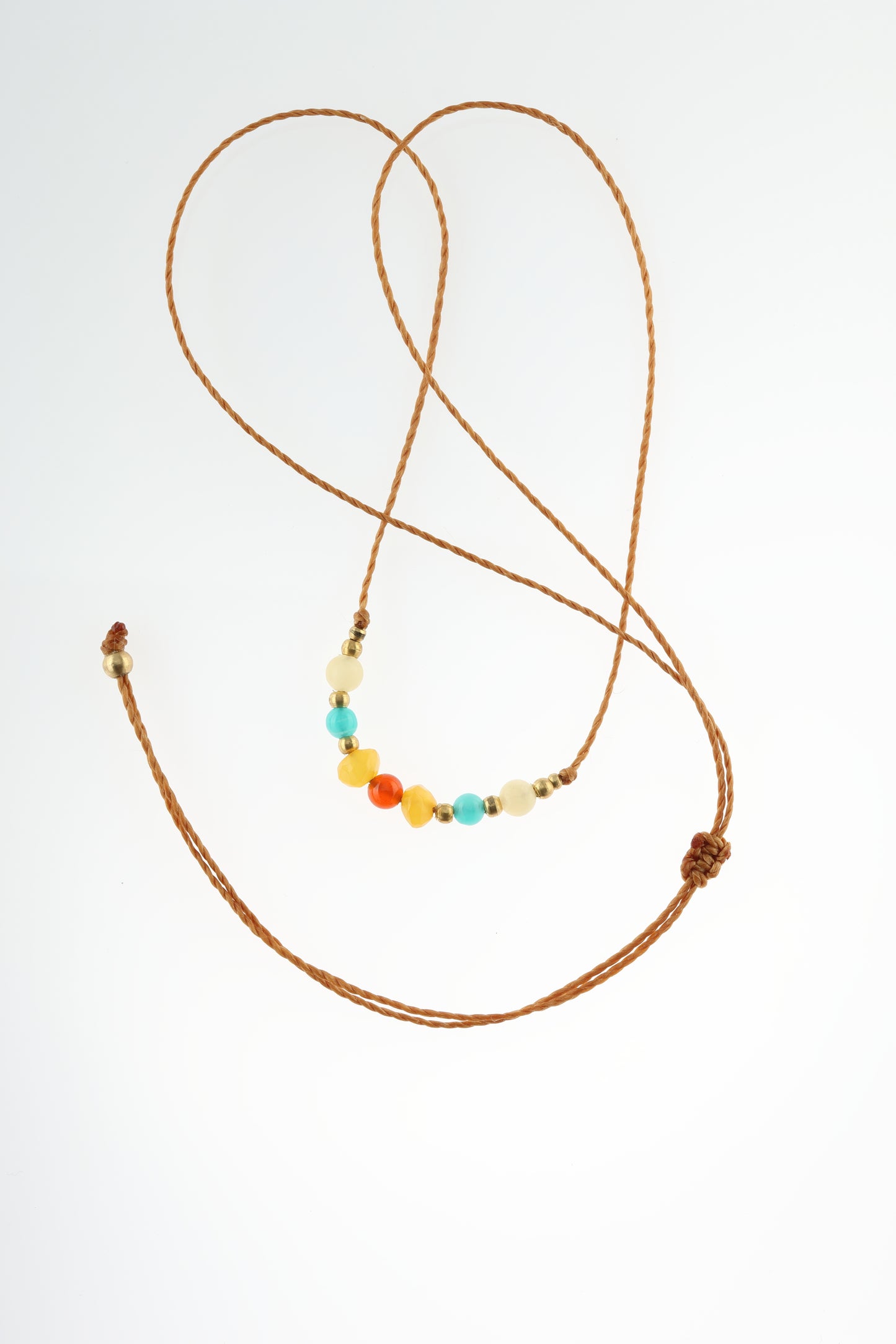 Halskette mit Edelstein- und Messingperlen an beigem Makrameegarn. Steine und Farbe: Calcit - creme, Amazonit - blau, Bernstein - gelb, Karneol - rot. Für Sternzeichen: Krebs