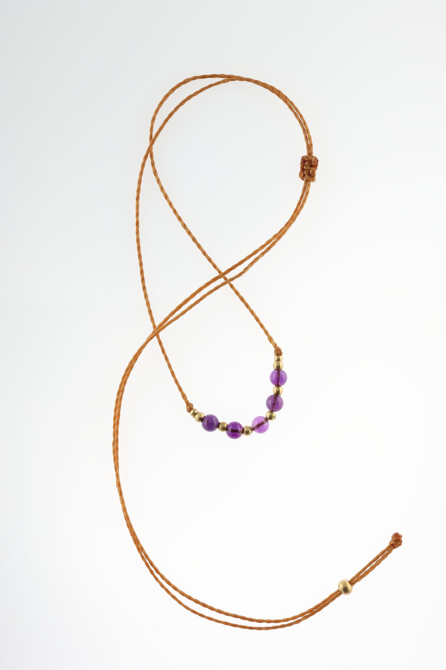 Halskette mit Edelstein- und Messingperlen an beigem Makrameegarn. Stein und Farbe: Amethyst – lila/klar. Für Affirmation: „Ich bin easy“