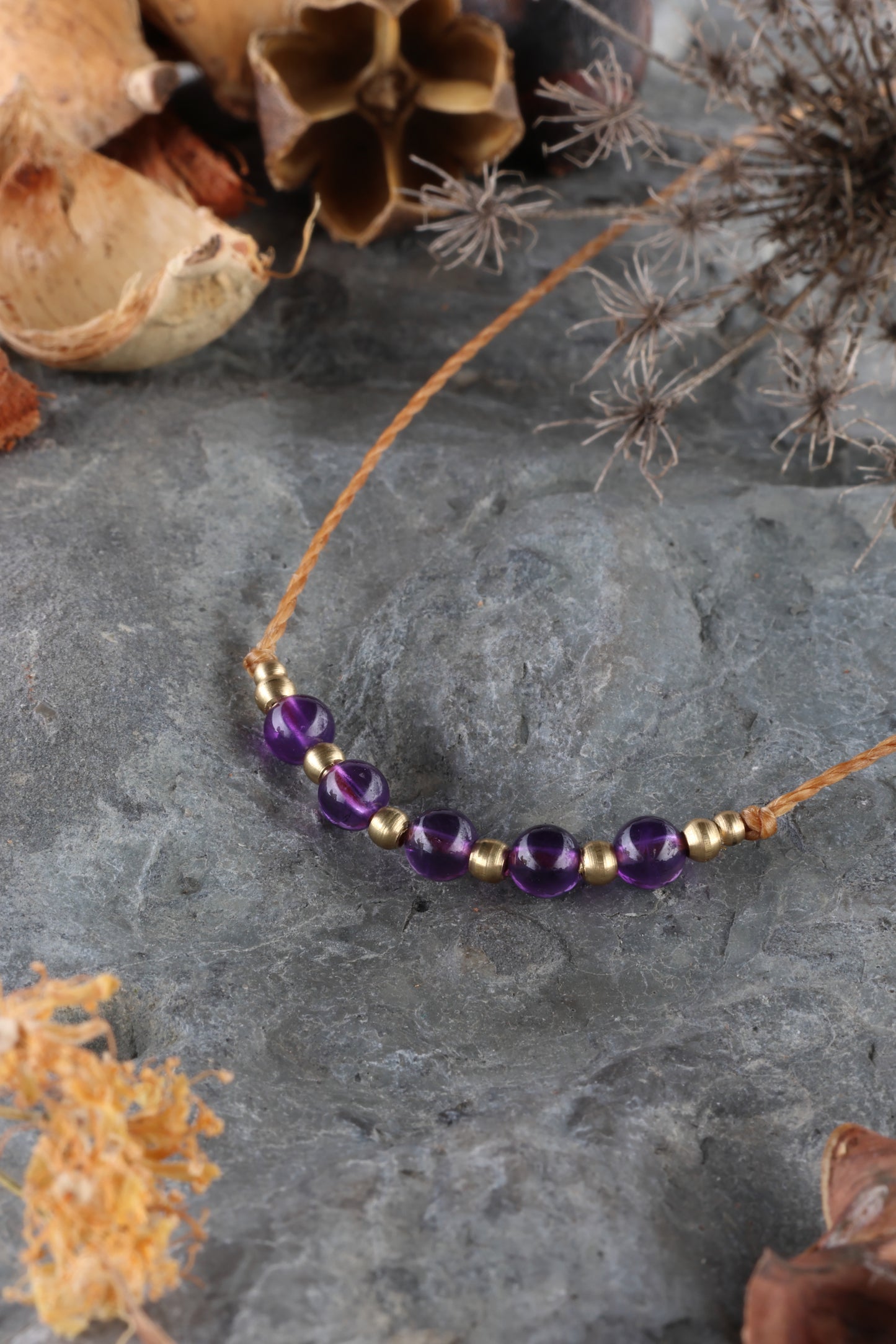 Halskette mit Edelstein- und Messingperlen an beigem Makrameegarn. Stein und Farbe: Amethyst – lila/klar. Für Affirmation: „Ich bin easy“