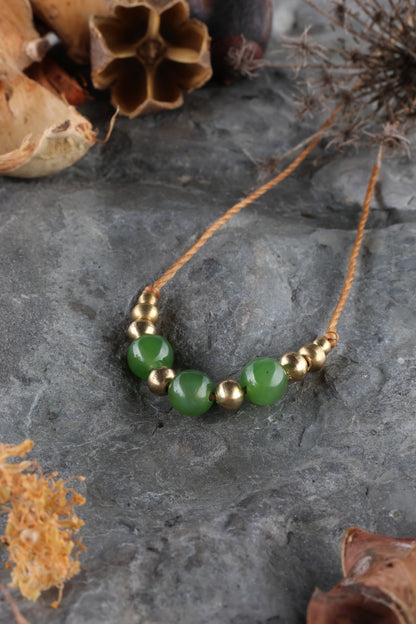 Halskette mit Edelstein- und Messingperlen an beigem Makrameegarn. Stein und Farbe: Jade – grün. Für Sternzeichen: Waage Dekade 3