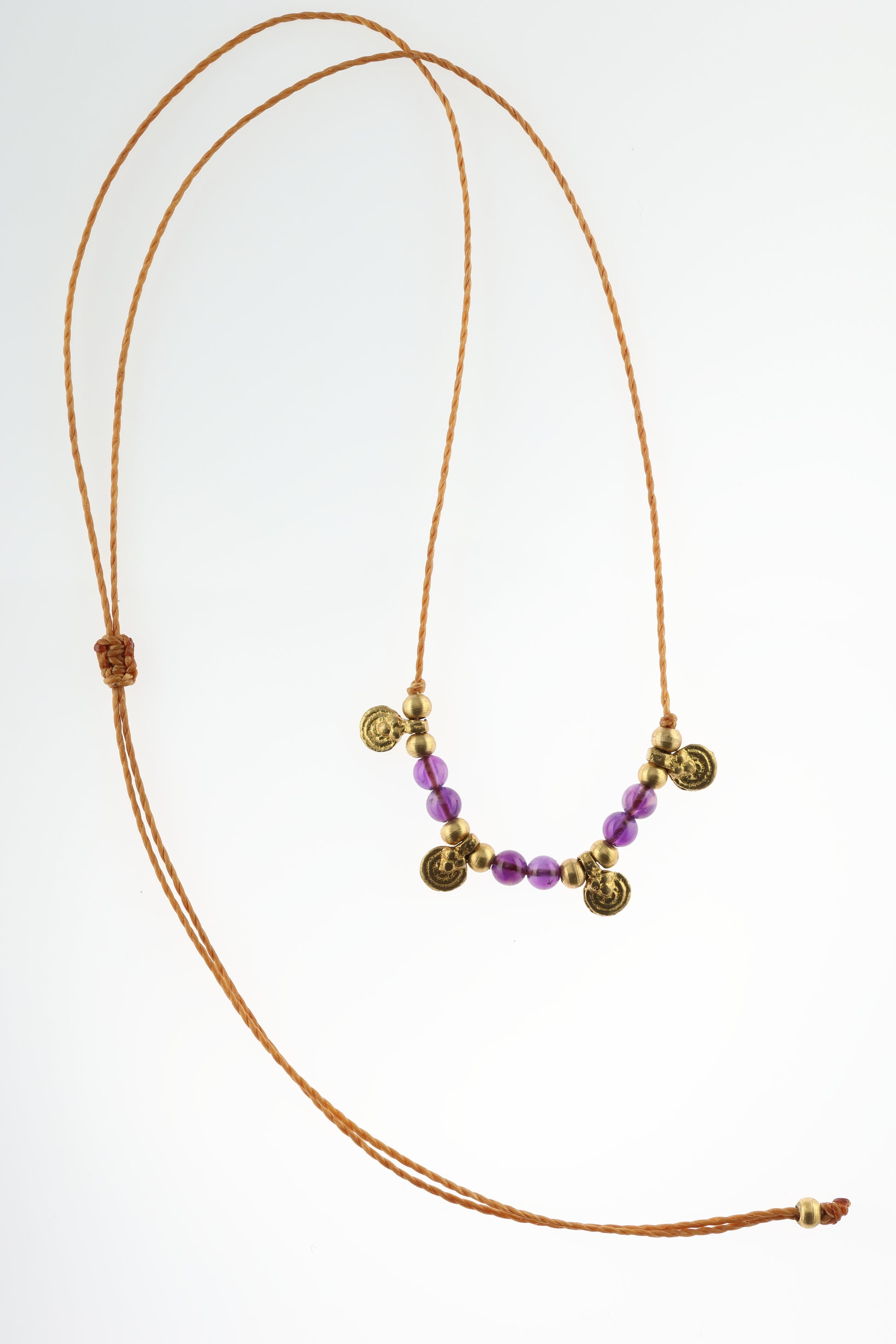 Halskette mit Edelstein- und Messingperlen sowie 4 kleinen runden Messinganhängern. Kette aus beigem Makrameegarn. Stein und Farbe: Amethyst – lila/klar. Für Affirmation: „Ich bin easy“